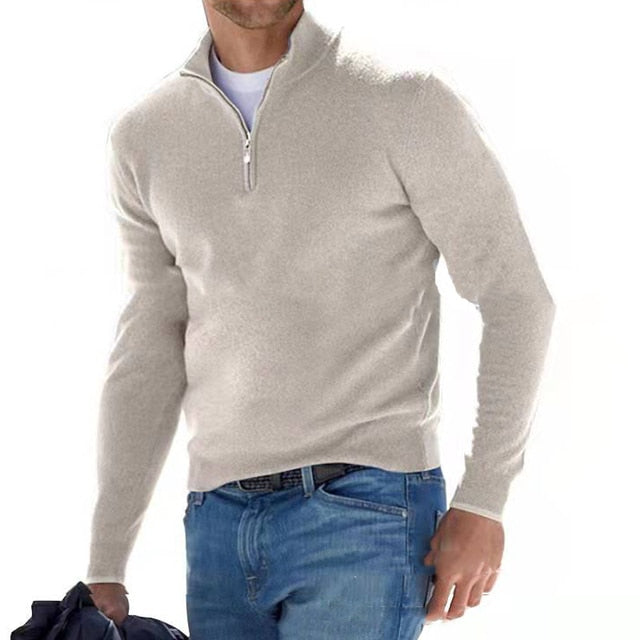 Homme en marche portant le pull beige clair à col zippé sur un t-shirt blanc, avec un jean bleu. 16