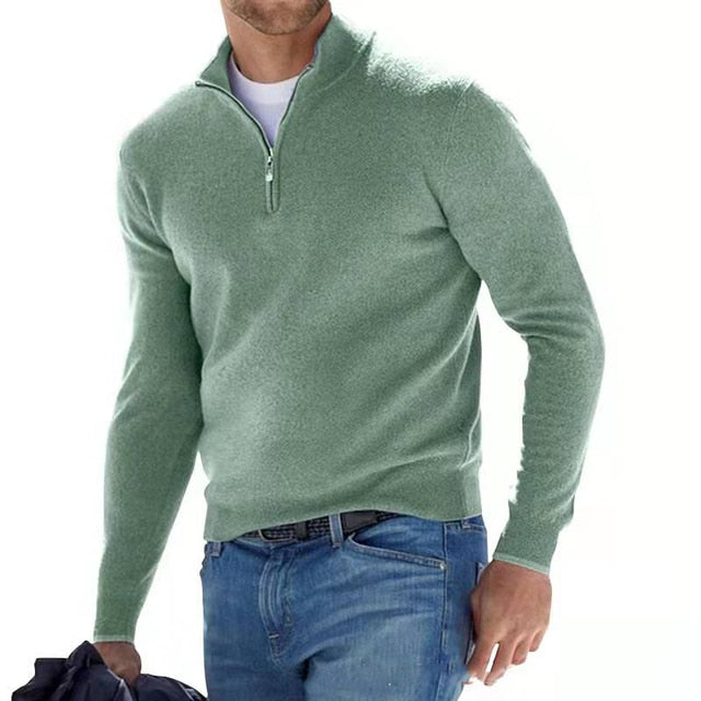 Homme marchant, vêtu du pull vert menthe à col zippé sur un t-shirt blanc, avec un jean et une veste à la main. 2