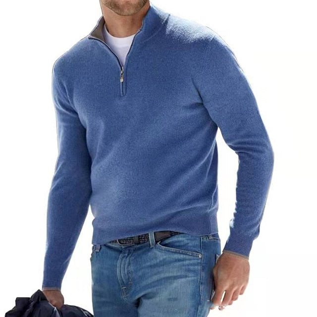Homme portant le pull bleu à col montant zippé, t-shirt blanc dessous, jean et veste sombre tenue à la main. 4