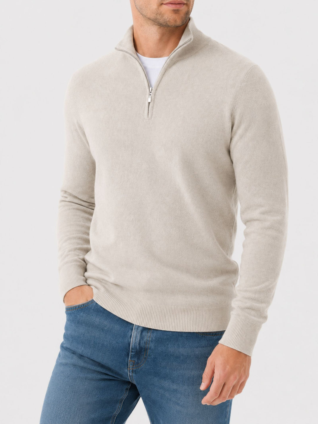 Homme portant le pull beige clair à col zippé, vue de trois quarts, une main dans la poche du jean. 9