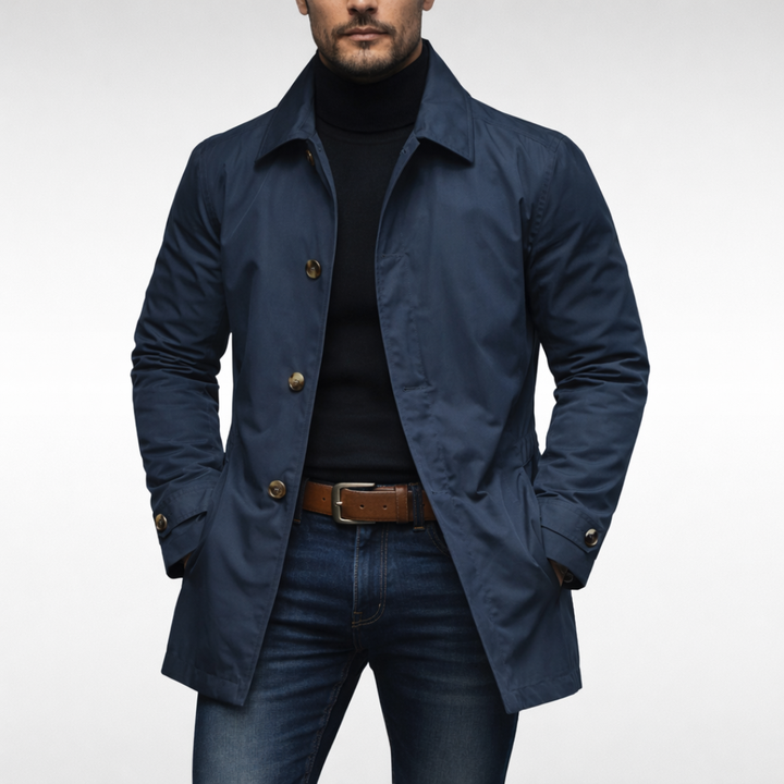 Manteau bleu marine à boutons dorés porté par un modèle, col roulé noir, ceinture en cuir marron et jean. 3