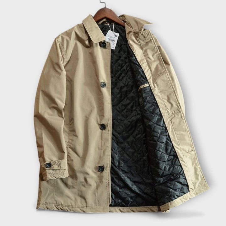 Manteau beige à plat sur cintre, ouvert pour montrer la doublure matelassée noire, le col rabattu et les boutons noirs. 7