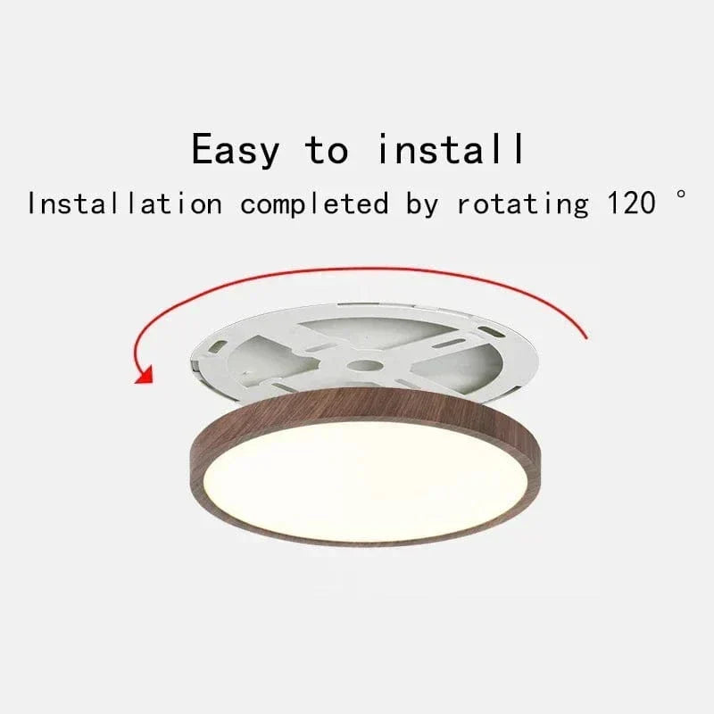 Plafonnier au cadre brun imitation bois, support de fixation blanc dégagé avec une flèche rouge indiquant la rotation pour l'installation. 1