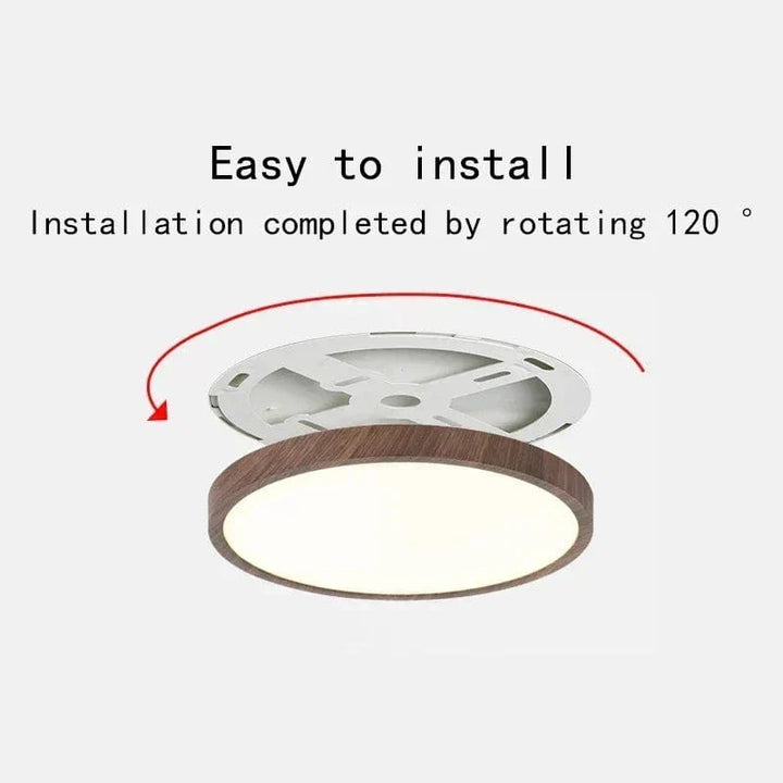 Plafonnier au cadre brun imitation bois, support de fixation blanc dégagé avec une flèche rouge indiquant la rotation pour l'installation. 1