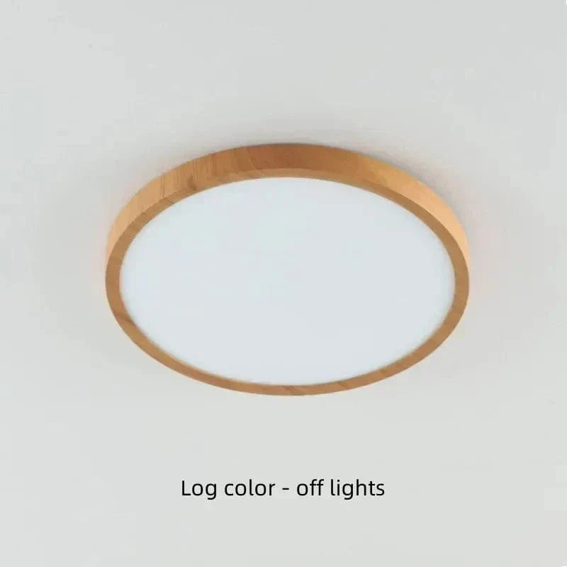 Plafonnier rond à cadre bois clair éteint, vu en légère contre-plongée sur un plafond blanc. 19