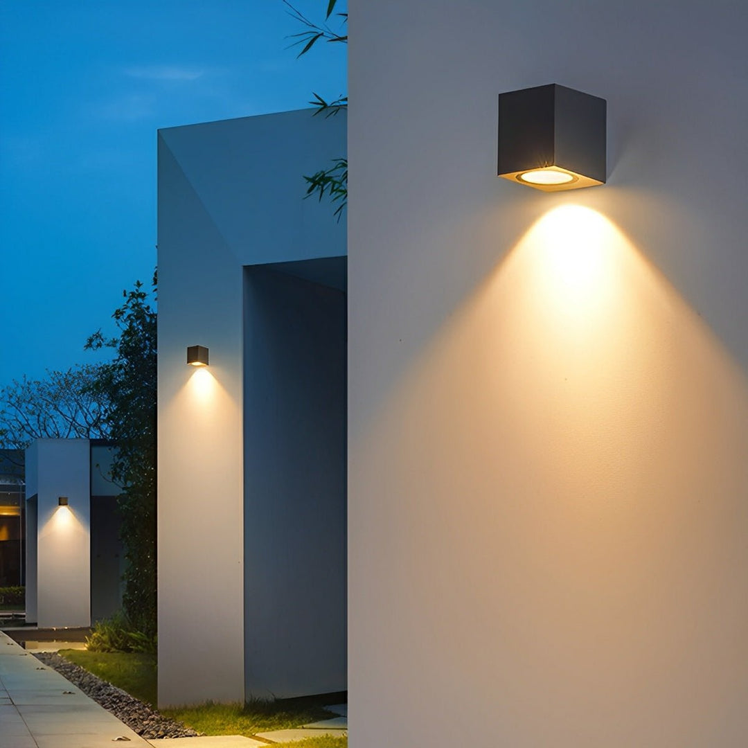Appliques cubiques noires alignées sur les murs d'une allée de jardin moderne, lumière chaude vers le bas 6