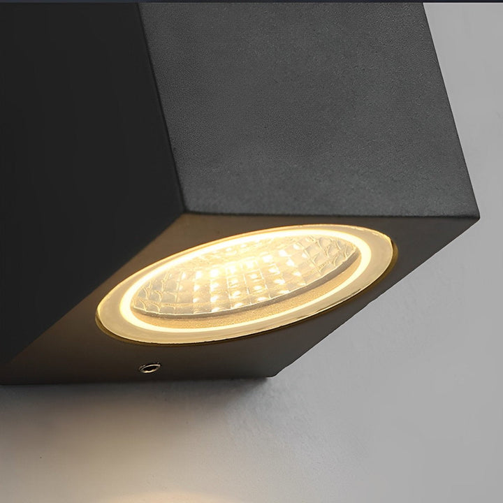 Gros plan sur la lentille LED allumée en dessous du boîtier noir, avec une petite vis visible 13