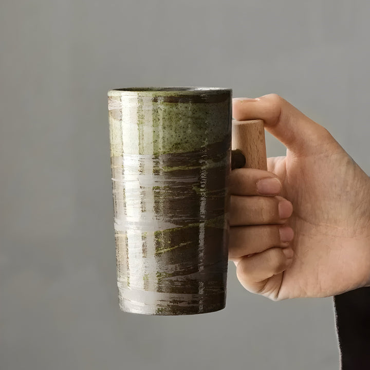 Main tenant par l'anse en bois la tasse en grès émaillé vert et brun 9