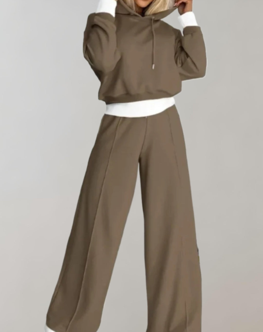 Ensemble taupe en vue de face, sweat court à capuche aux poignets et bas blancs, pantalon large à pli marqué. 5