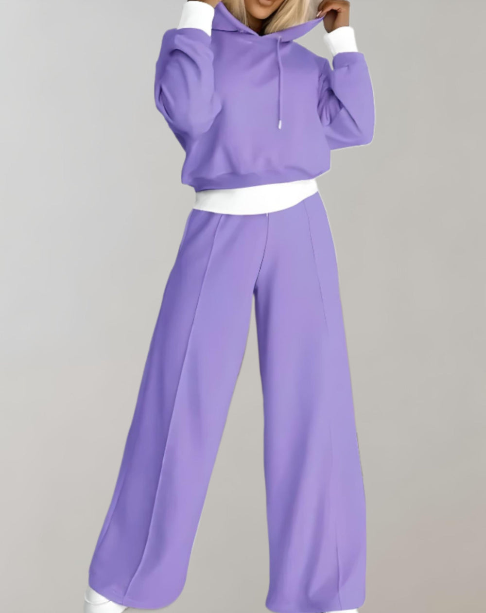 Ensemble lilas porté en pied, sweat à capuche à poignets et bas contrastés blancs, pantalon large à surpiqûre centrale. 2