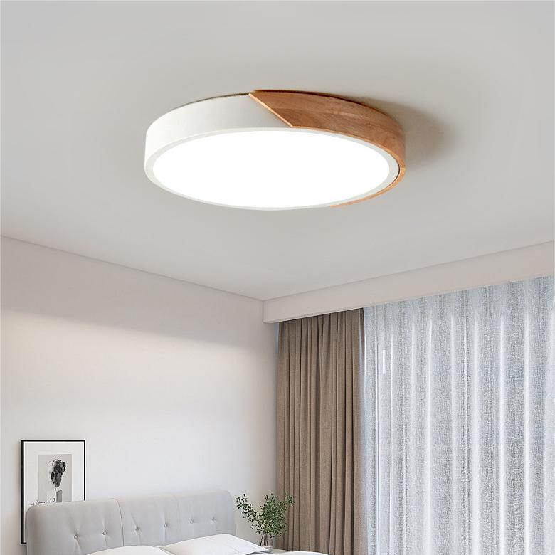 Plafonnier blanc à segment en bois allumé dans une chambre avec tête de lit gris clair et rideaux. 3