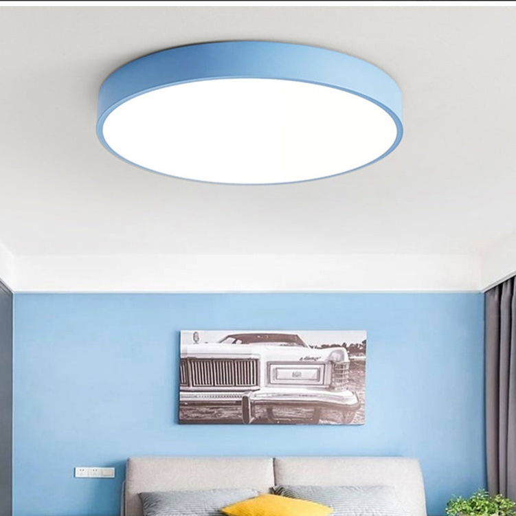 Plafonnier rond bleu clair monté au plafond d'une chambre aux murs bleus, au-dessus d'un lit. 4