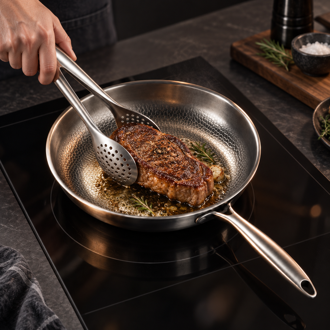 Une main saisit un steak grillé avec la pince perforée dans une poêle en acier inoxydable sur plaque à induction. 9