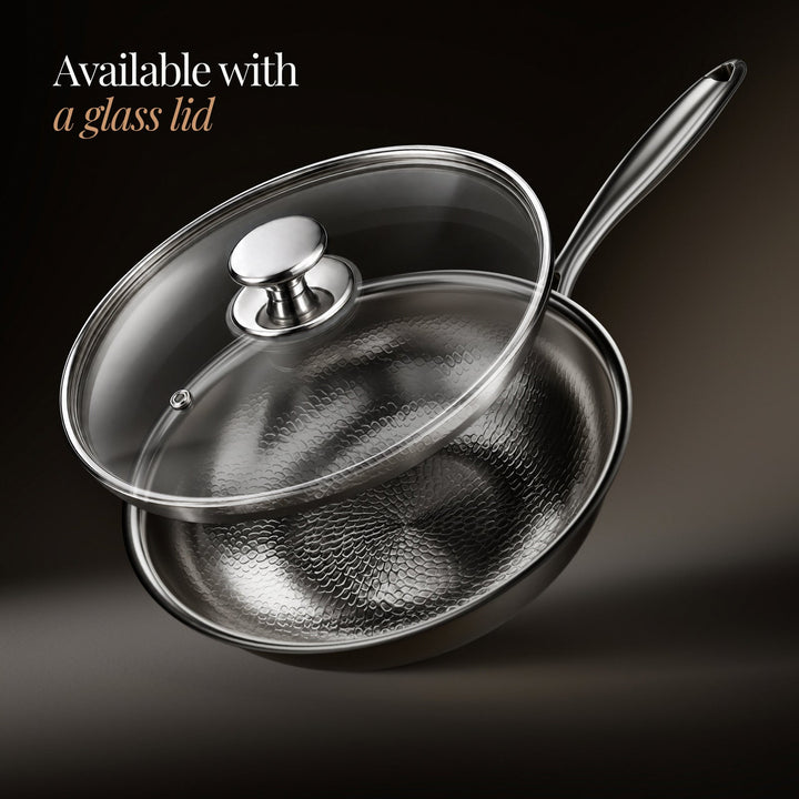 Wok martelé avec son couvercle en verre transparent à bouton métallique soulevé au-dessus de la poêle. 3