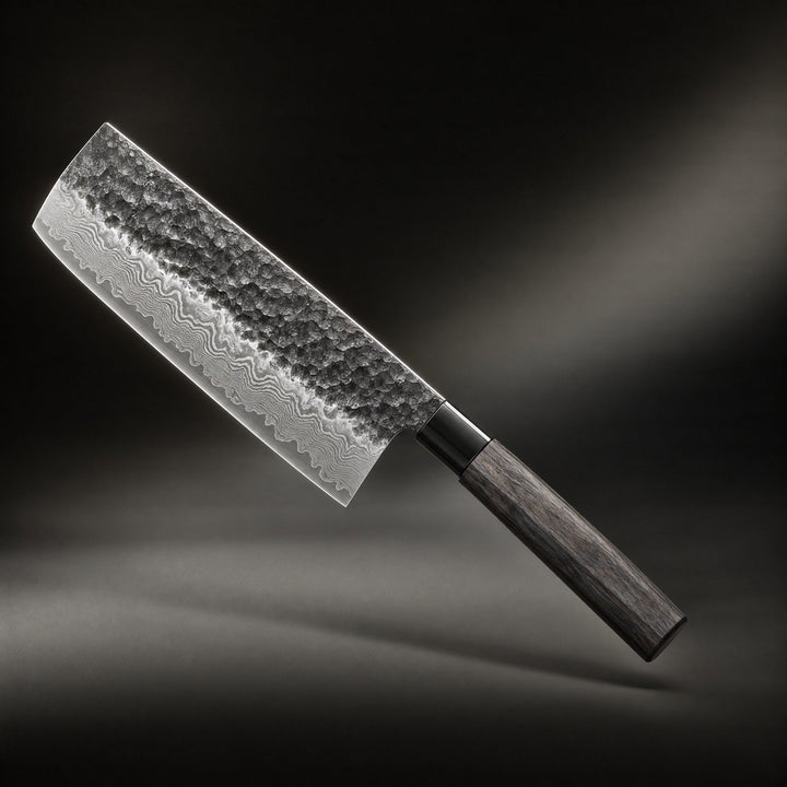 Couteau à lame rectangulaire martelée aux veines d'acier stratifié et manche octogonal en bois sombre, photographié en diagonale sur fond noir. 1