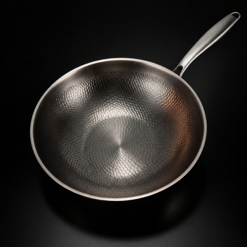 Wok vide photographié du dessus, montrant la texture martelée du fond et des parois et le manche. 2
