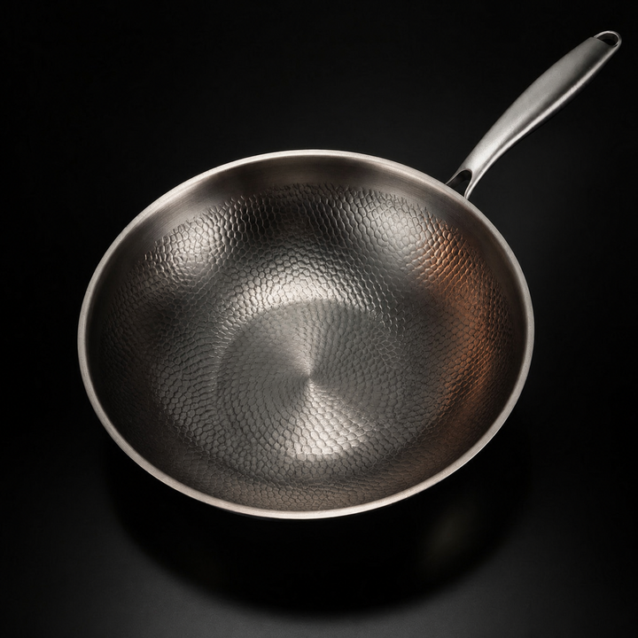 Wok vide photographié du dessus, montrant la texture martelée du fond et des parois et le manche. 2