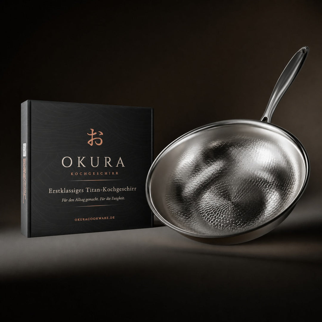 Wok martelé incliné posé à côté de son coffret noir d'emballage, sur fond sombre. 8