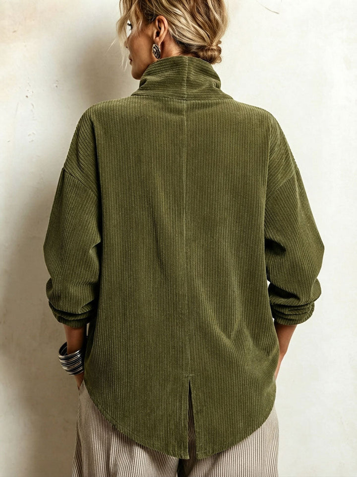 Vue de dos du pull vert en velours côtelé, avec col montant, couture centrale, petite fente et ourlet arrondi, porté par un mannequin. 2
