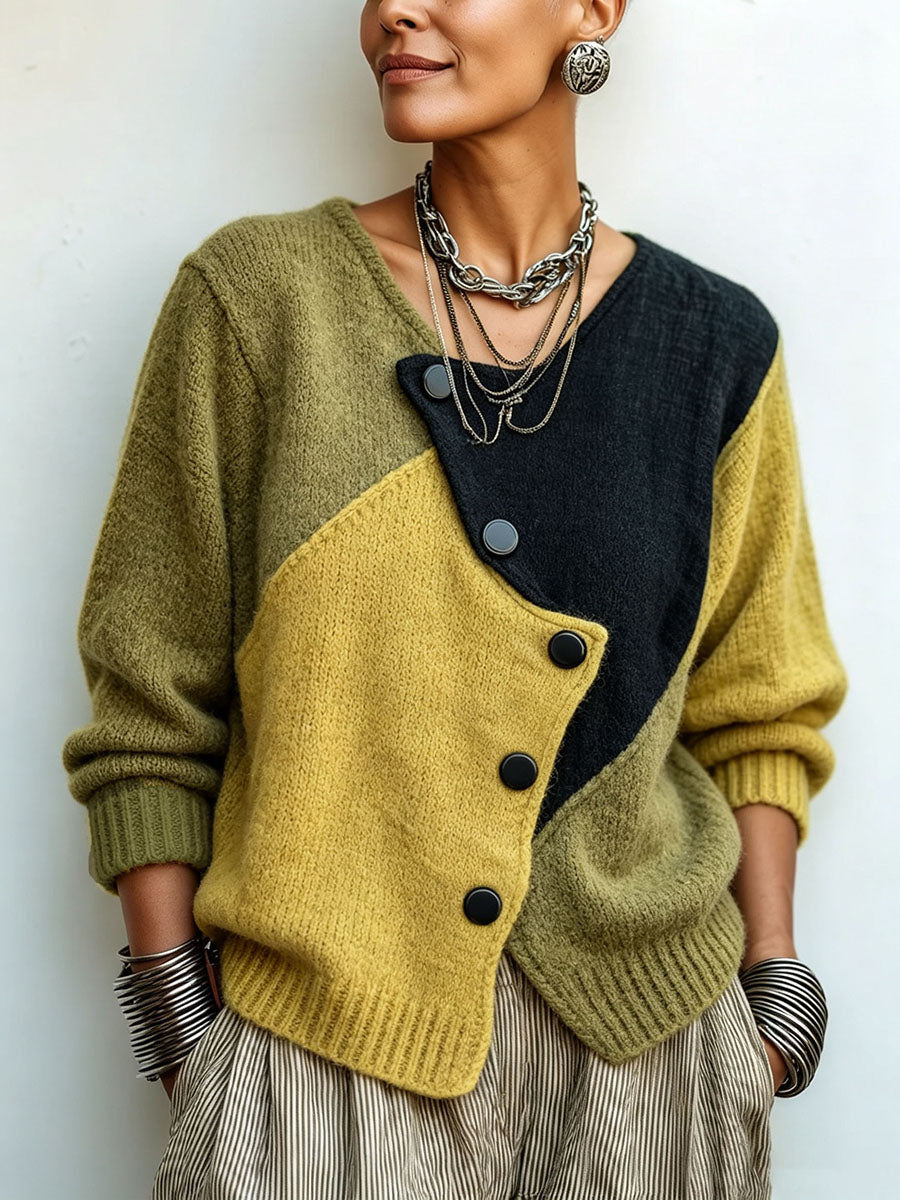 Vue de face rapprochée du pull vert, jaune et noir à boutons asymétriques, porté avec un pantalon rayé et des bijoux argentés. 1