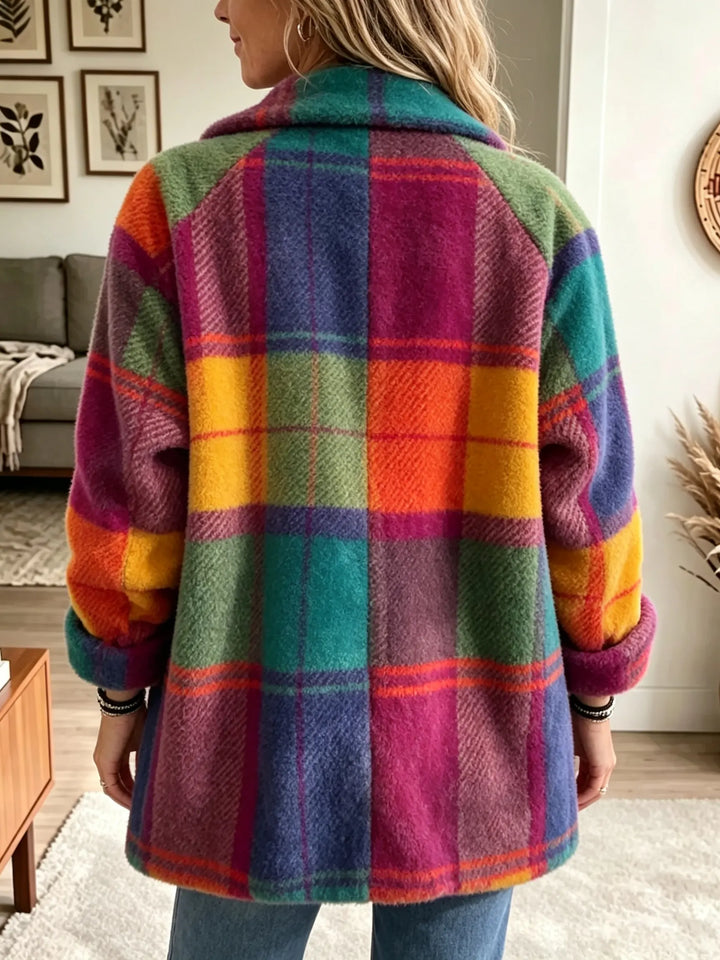 Vue de dos du manteau à carreaux colorés, manches raglan retroussées, porté avec un jean dans un intérieur lumineux. 3