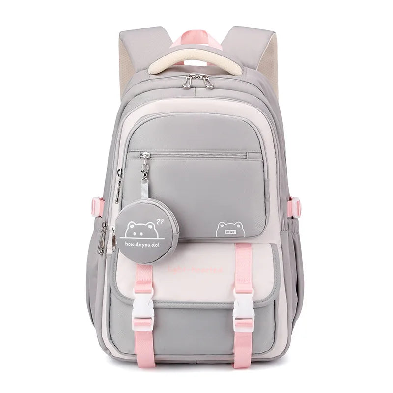 Sac à dos gris et crème vu de face, avec sangles et détails roses, rabat à boucles et pochette ronde. 10