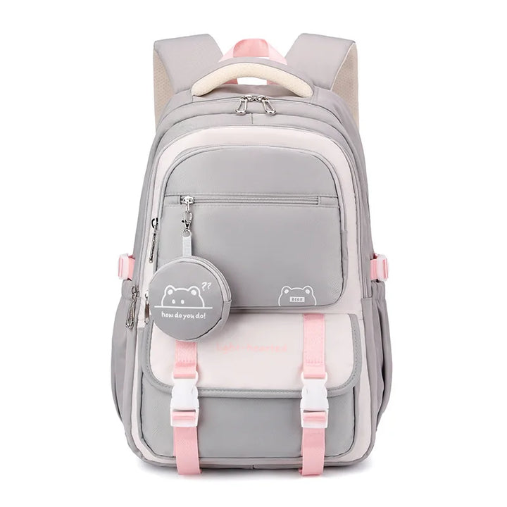 Sac à dos gris et crème vu de face, avec sangles et détails roses, rabat à boucles et pochette ronde. 10