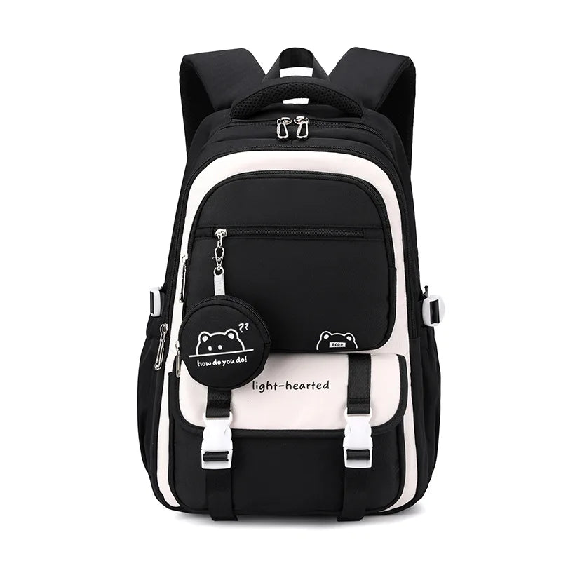 Sac à dos noir et crème vu de face, avec rabat à boucles blanches et pochette ronde noire assortie. 11