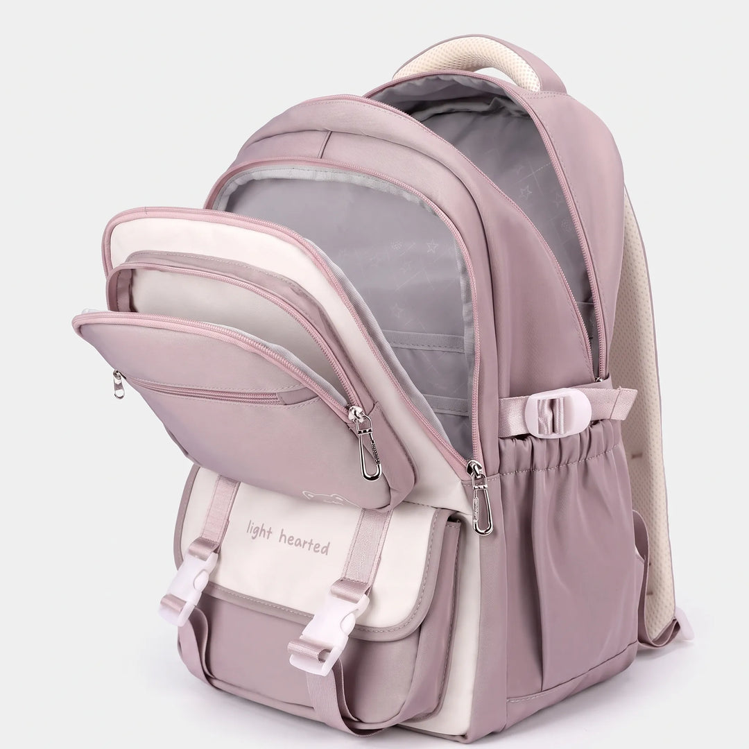 Sac à dos mauve ouvert en trois compartiments, doublure grise visible, rabat avant à boucles et poche latérale élastique. 3