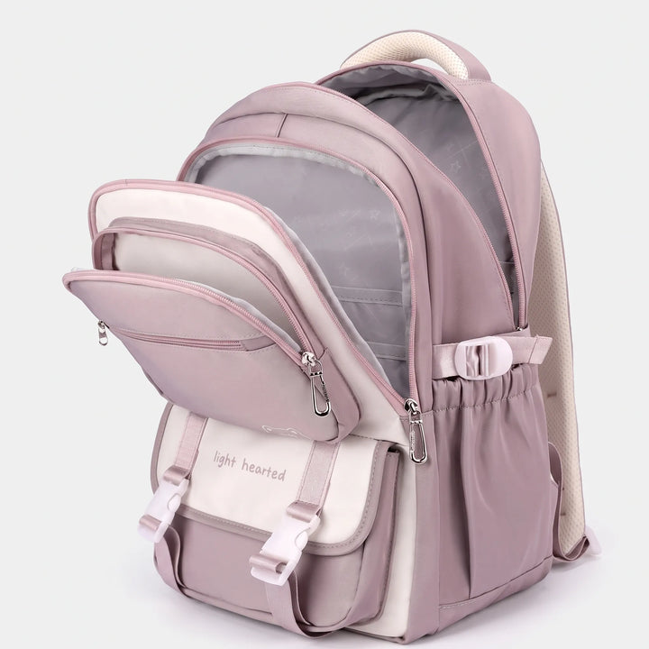 Sac à dos mauve ouvert en trois compartiments, doublure grise visible, rabat avant à boucles et poche latérale élastique. 3