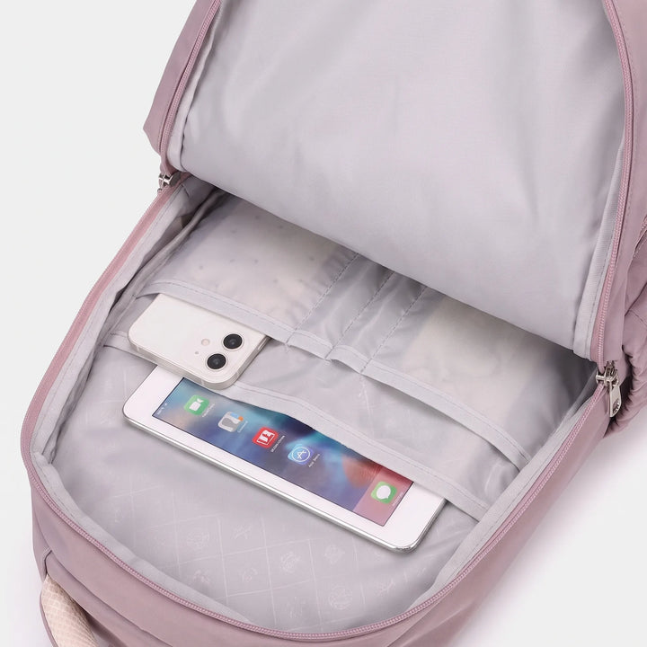 Intérieur du sac à dos mauve avec doublure grise, pochettes de rangement contenant un smartphone et une tablette. 4