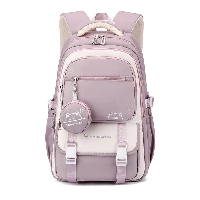 Sac à dos mauve et crème vu de face sur fond blanc, avec pochette ronde accrochée à la poche zippée. 6