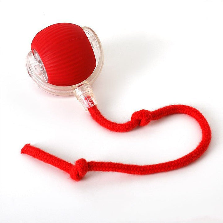 Balle rouge nervurée dans sa coque transparente, avec sa corde rouge à deux nœuds, sur fond blanc. 10