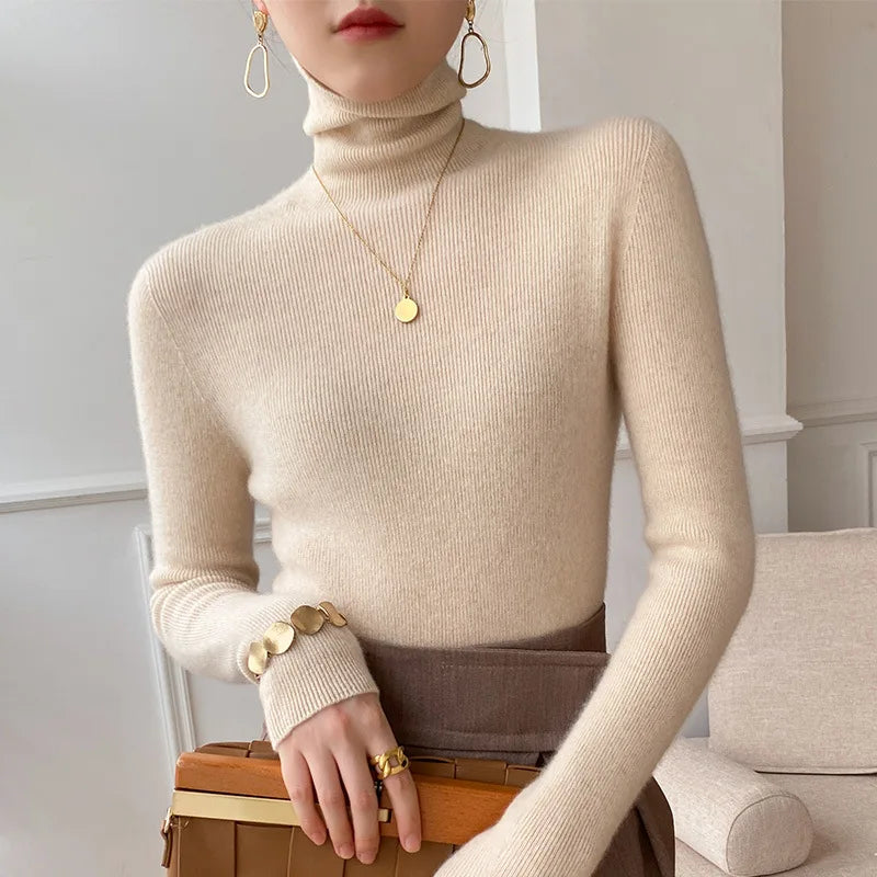 Pull beige à col roulé porté avec jupe marron, collier et bracelet dorés 1