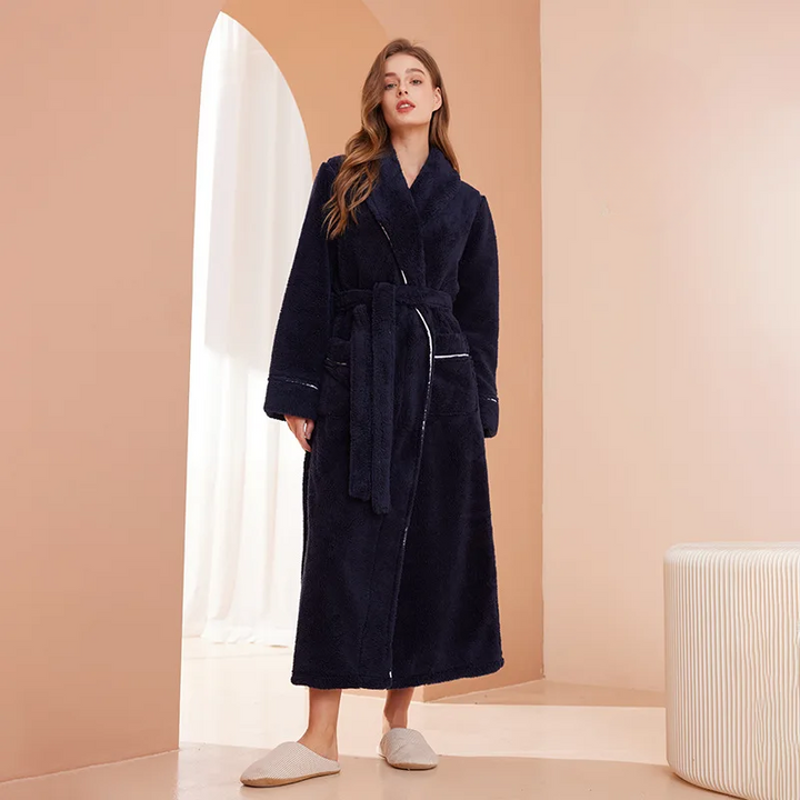 Femme en peignoir bleu marine moelleux, ceinture nouée, debout dans un décor beige à arche 1