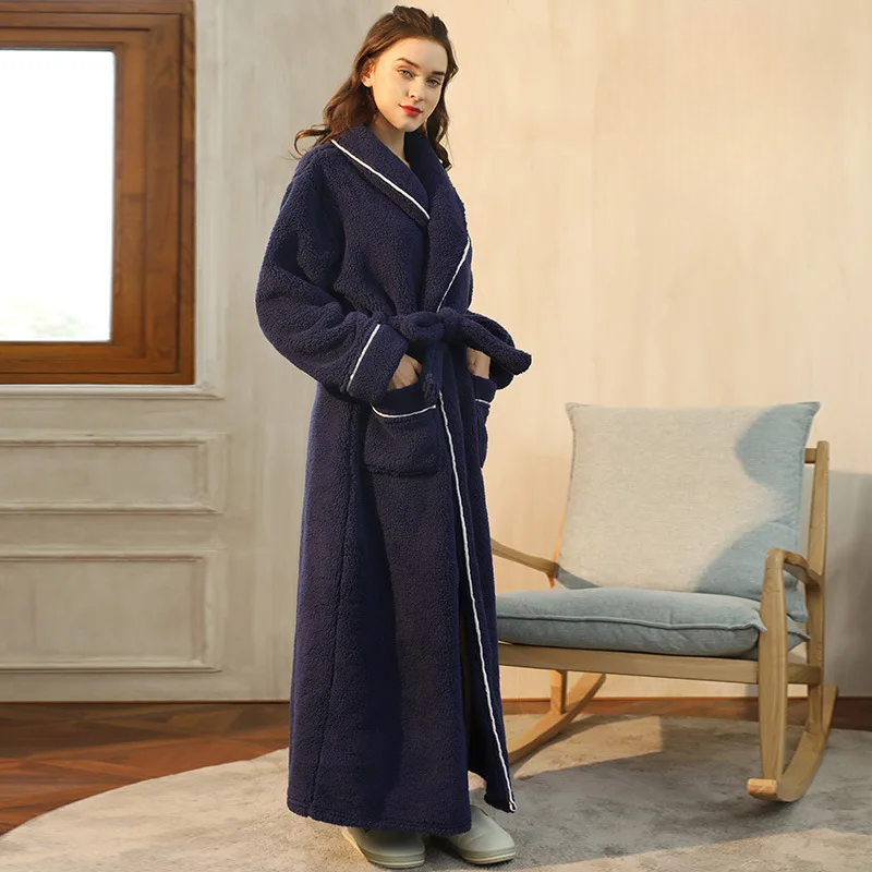 Peignoir bleu nuit vu de profil, mains dans les poches, devant un fauteuil à bascule en bois 10