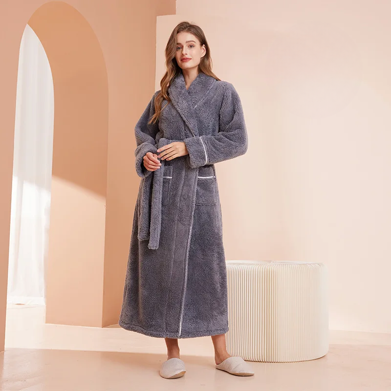 Peignoir gris ardoise à col châle, mains jointes sur la ceinture, près d'un pouf rayé crème 11