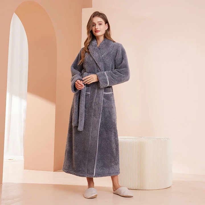 Peignoir gris ardoise à col châle, mains jointes sur la ceinture, près d'un pouf rayé crème 11