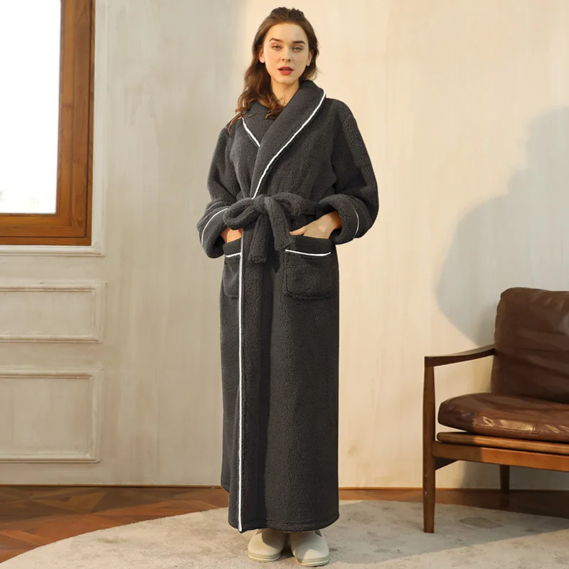 Peignoir gris anthracite à liseré blanc, mains dans les poches, porté dans un salon avec fauteuil en cuir 2