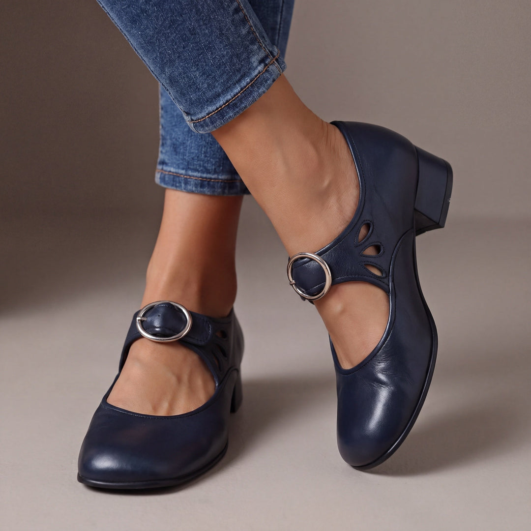 Escarpins bleu marine à talon bloc et boucle ronde argentée, portés avec un jean, découpes en goutte sur le côté. 4
