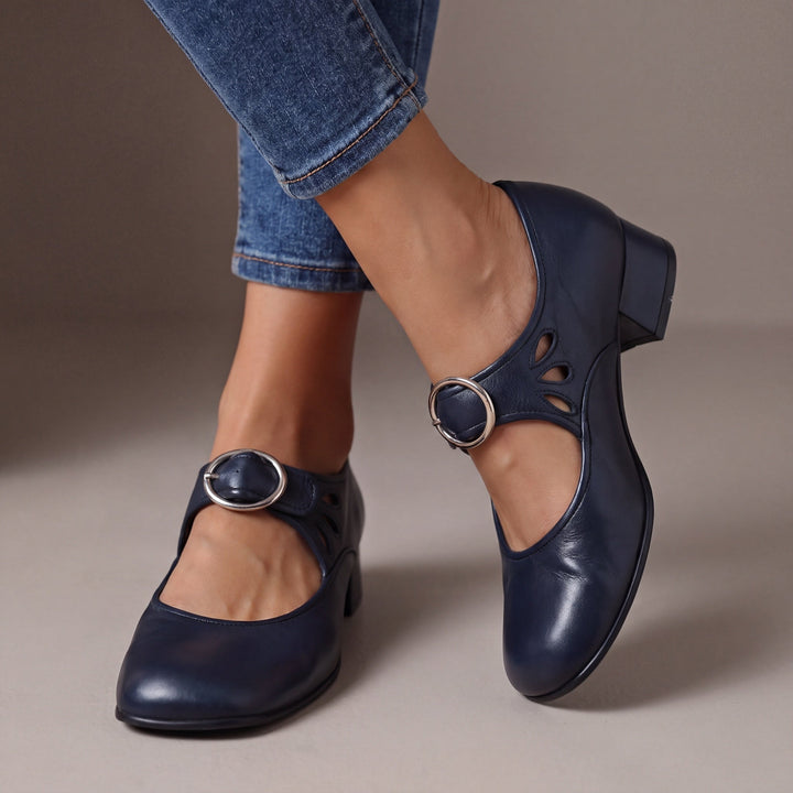 Escarpins bleu marine à talon bloc et boucle ronde argentée, portés avec un jean, découpes en goutte sur le côté. 4