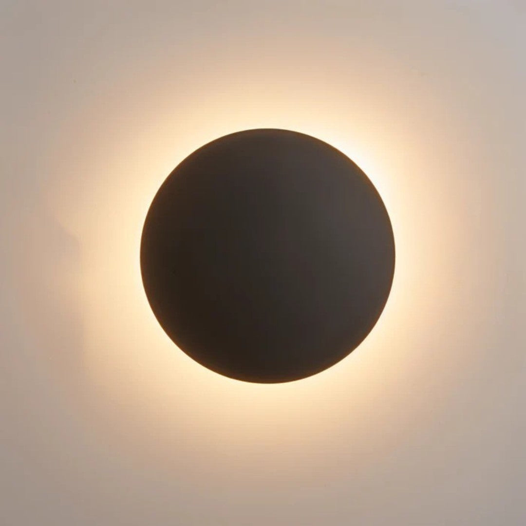 Disque noir vu de face, avec un halo de lumière chaude tout autour 2