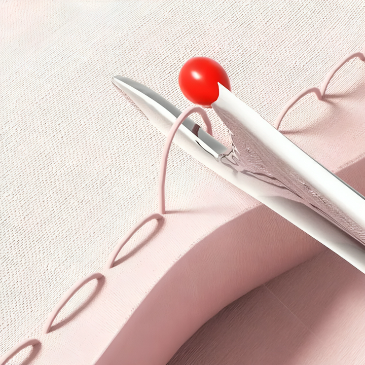 Découd-vite à tête rouge coupant les points d'une couture sur un tissu rose, vue rapprochée 4