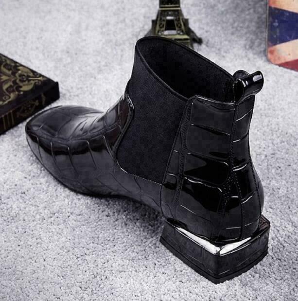 Boot noire vernie vue de trois quarts arrière, détail du talon carré à liseré argenté, de la languette de tirage et de l'élastique. 3