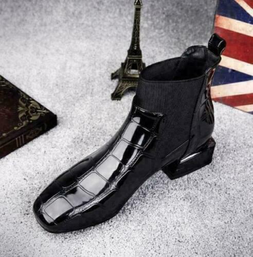 Boot noire à motif croco vernis et élastique latéral, vue de trois quarts avant sur moquette grise, décor parisien en arrière-plan. 5