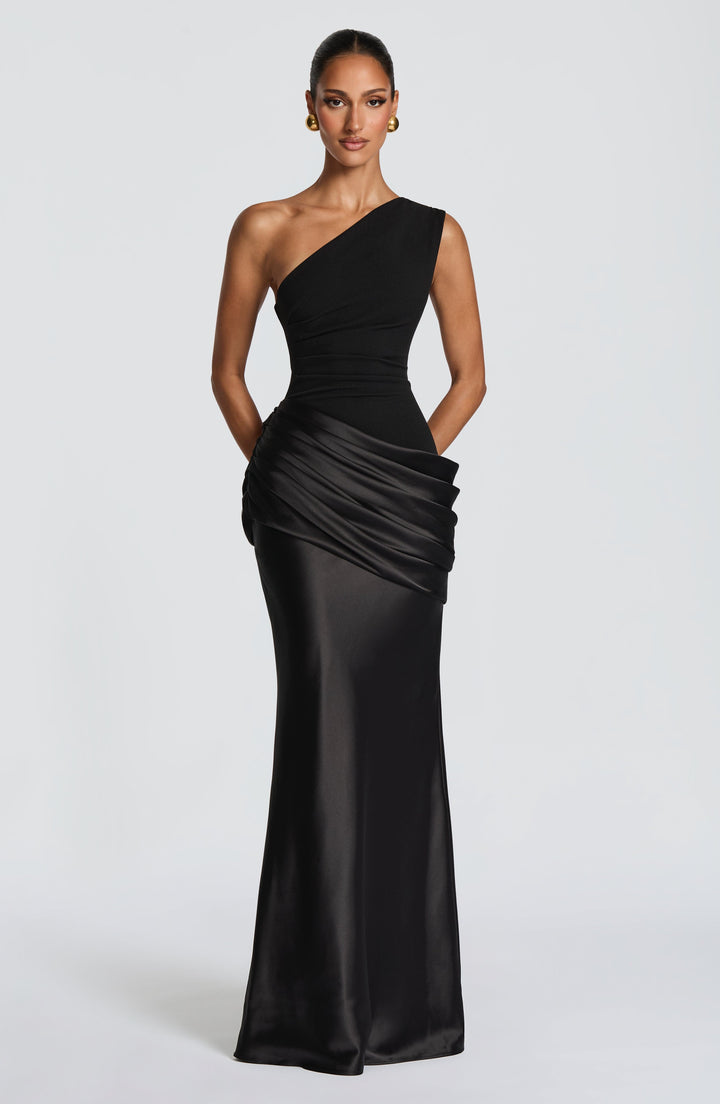 Robe longue prune portée de face en pied, mains dans le dos, buste plissé et drapé en satin. 20