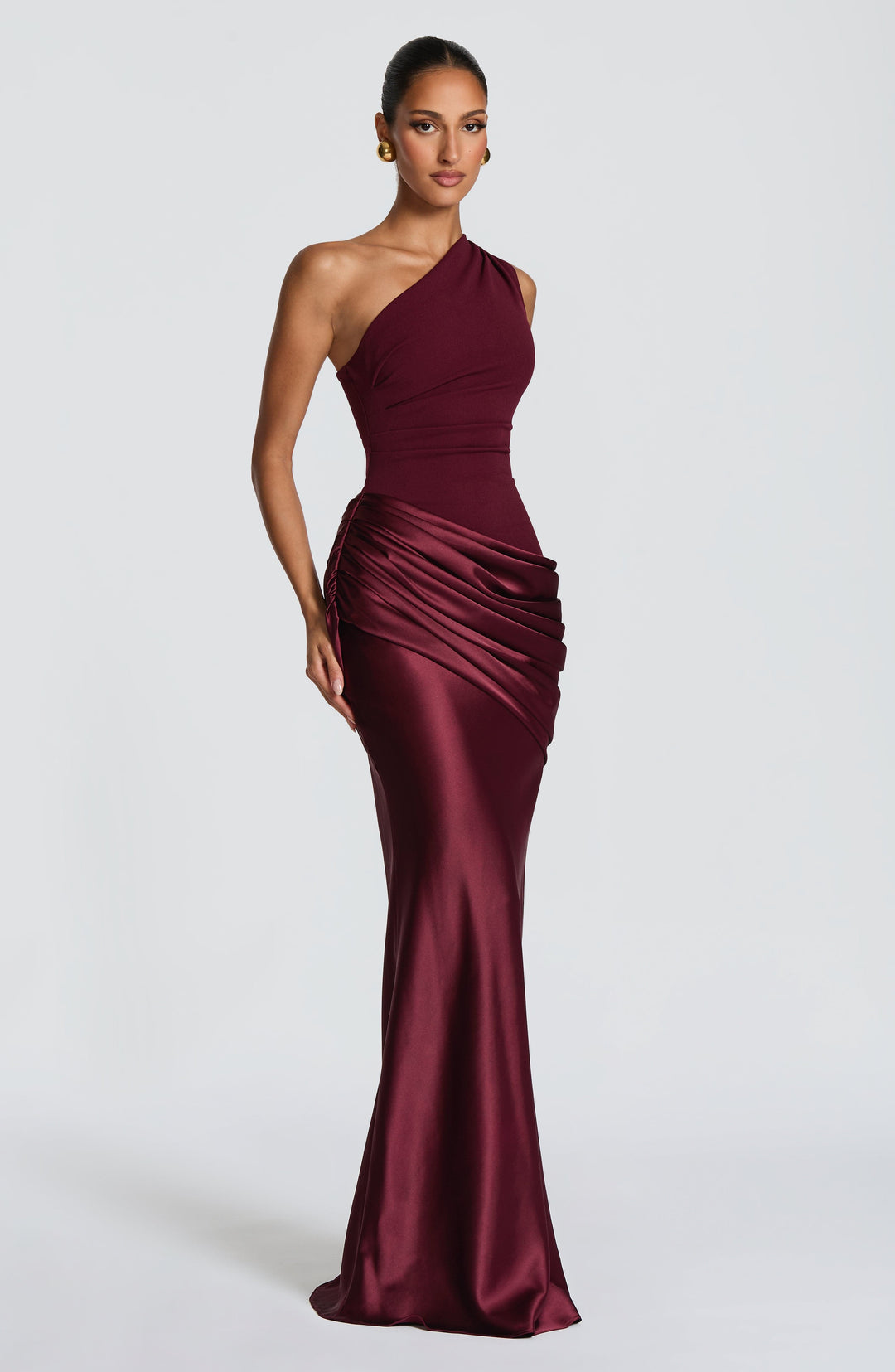 Robe longue prune portée de face avec de grandes boucles d'oreilles dorées, drapé en satin sur la hanche. 14