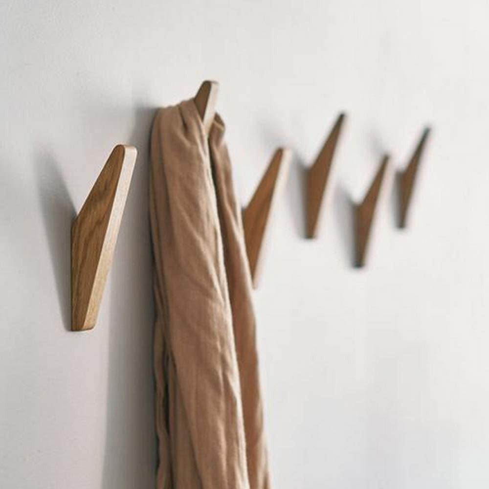 Rangée de crochets en bois fixés au mur blanc, une écharpe beige drapée sur l'un d'eux, vue en perspective. 2