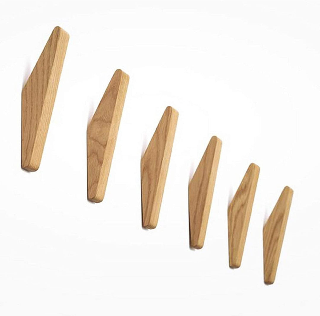 Six crochets en bois clair aux veines visibles, alignés en diagonale sur fond blanc, de face et de taille décroissante. 5