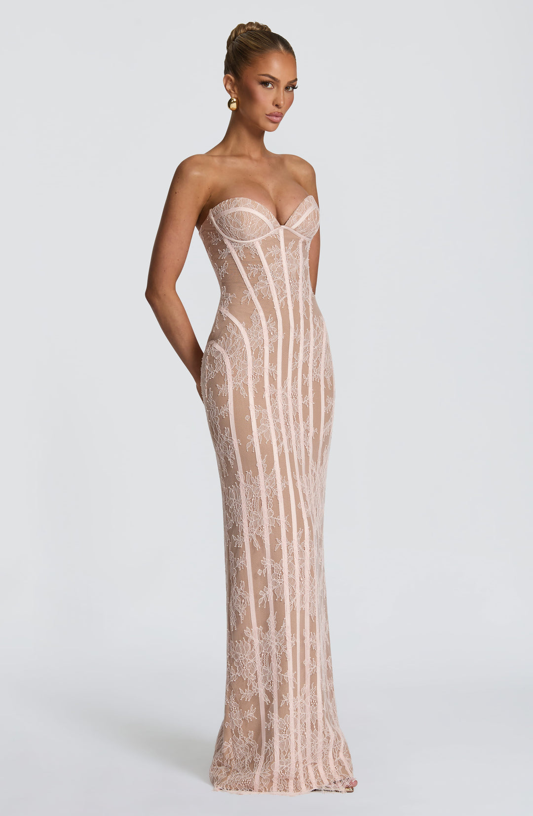 Robe rose pâle en dentelle portée de trois quarts, mannequin de profil, silhouette longue et ajustée. 16
